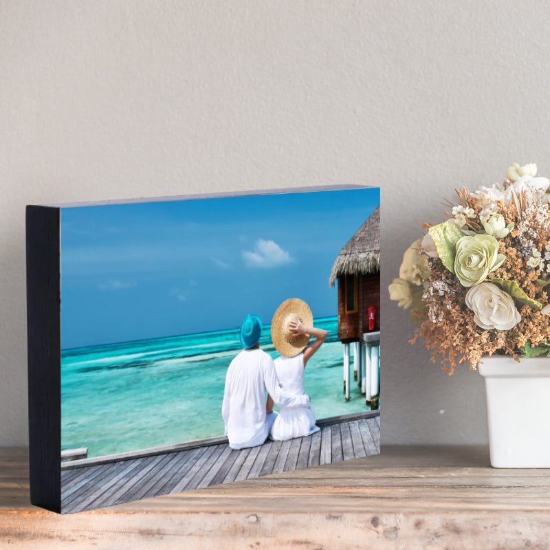 Photo on a wodden block, sitting on a shelf.