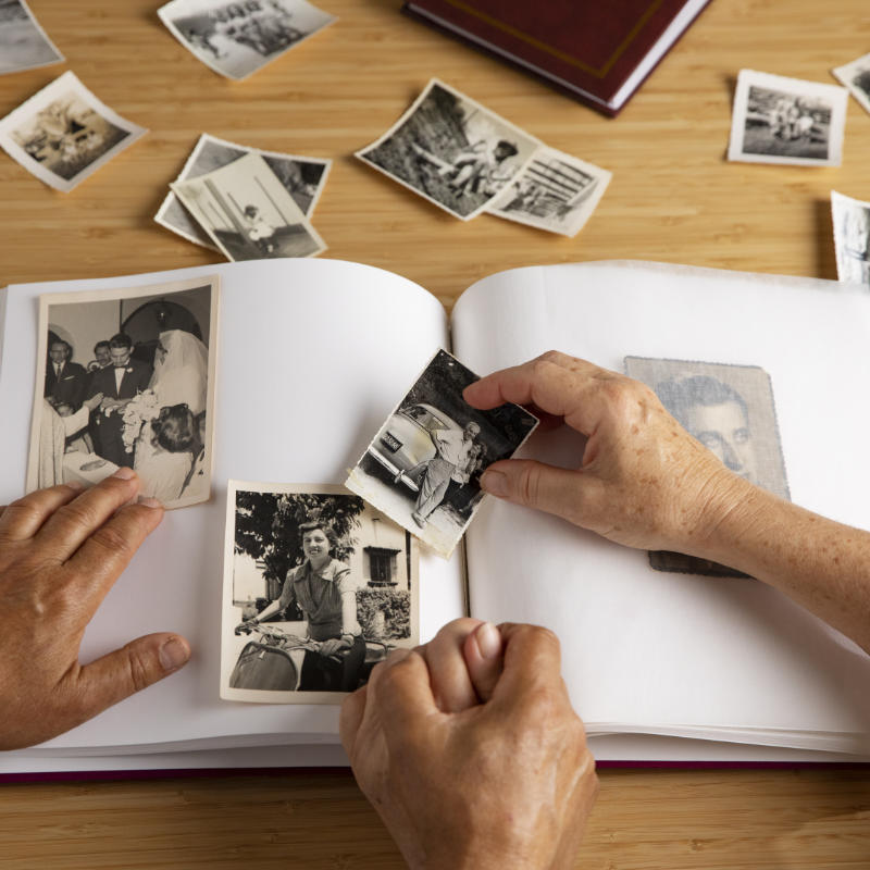 keeping memories safe and alive by putting old photos into a photo album