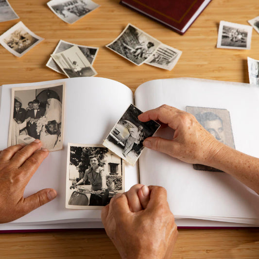 keeping memories safe and alive by putting old photos into a photo album