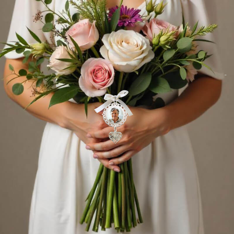 A weddi9ng bouquet photo charm with a heart pendant, remembering a lovedone on your wedding day.