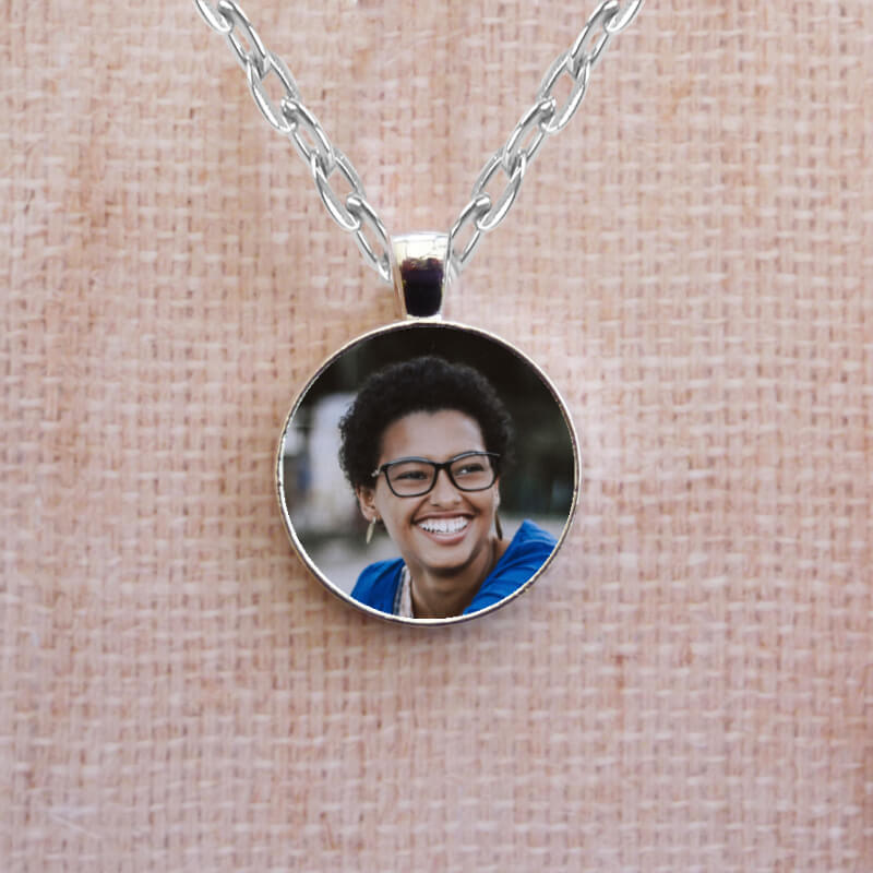 Personalised necklace chain with two photos. There is a photo on each side in a silver circular setting.
