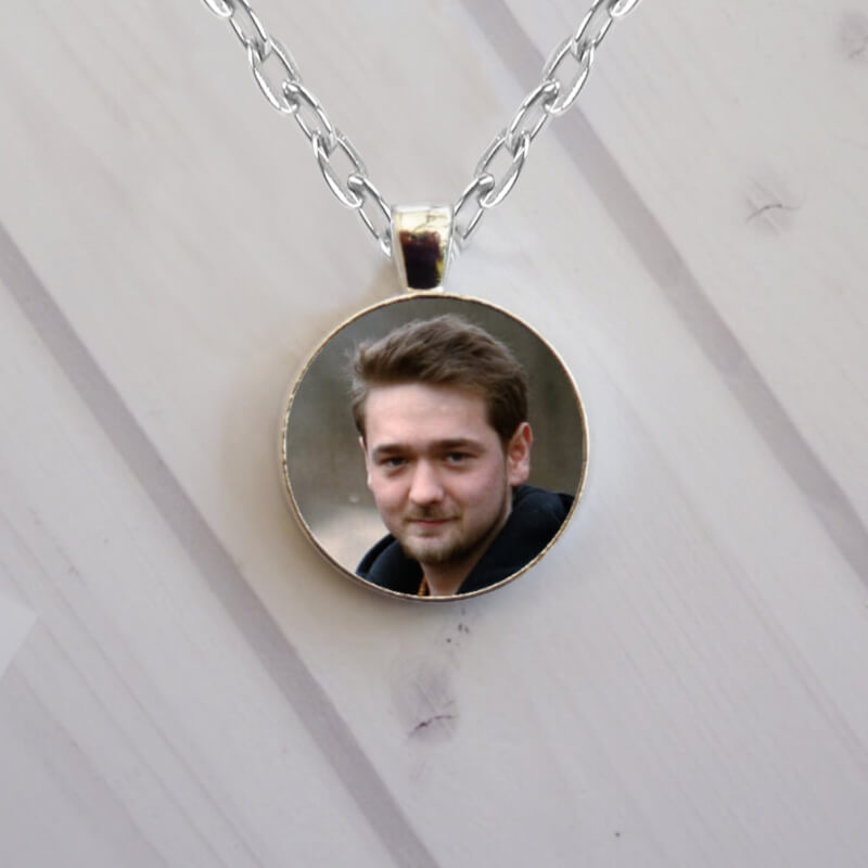 Circular silver photo necklace locket with a picture on each side. Custom-made in Ireland with fast delivery.