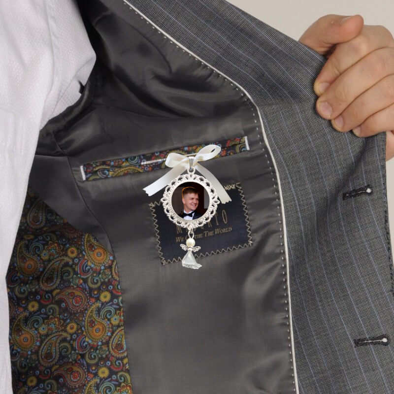 A groom's inside jacket featuring a wedding charm with a photo of someone special.