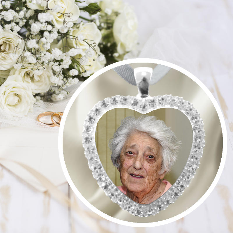 A bride's wedding memorial bouquet charm with photo of someone special in a silver heart with rhinestones.