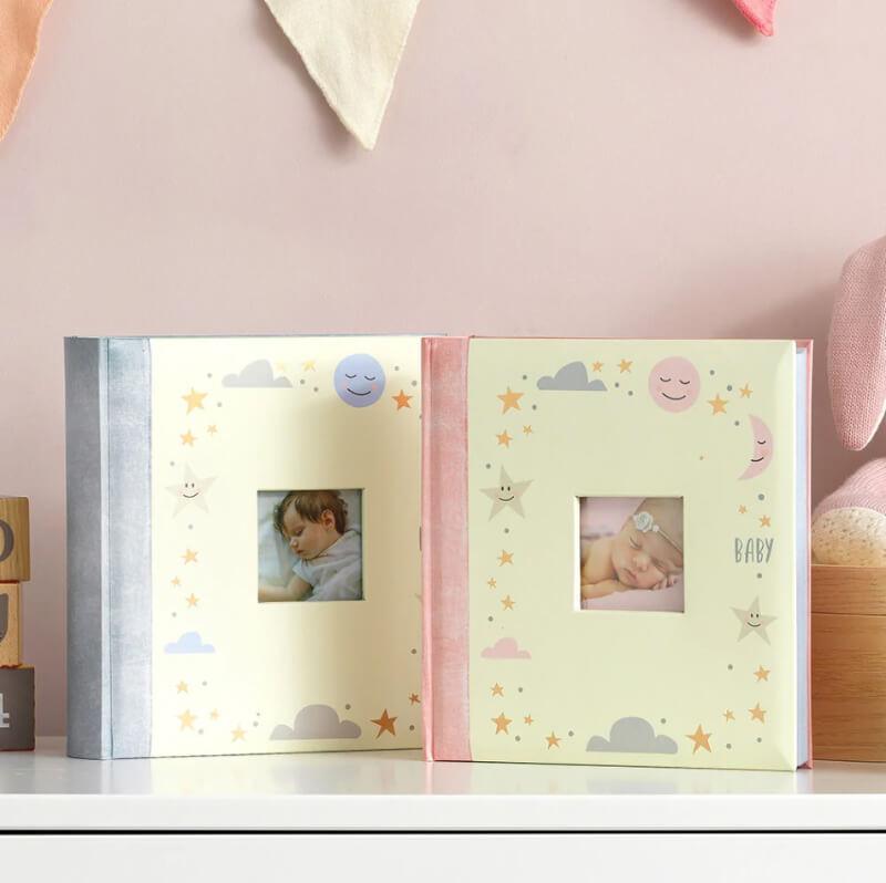 A boy and girl baby photo album that holds 200 photos and has space for swriting a note beside each photo.