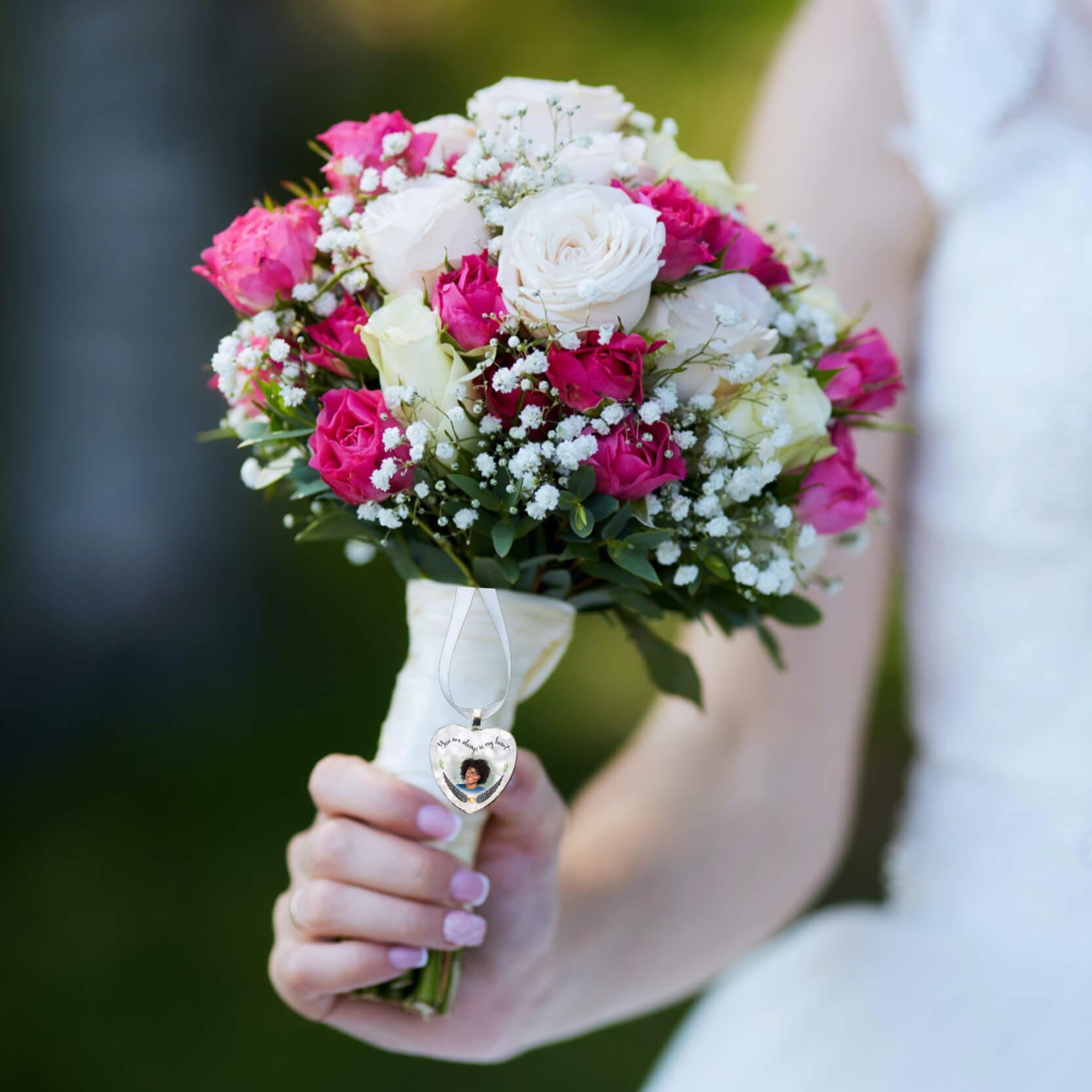 A bridal bouquet with a photo wedding charm attached.
